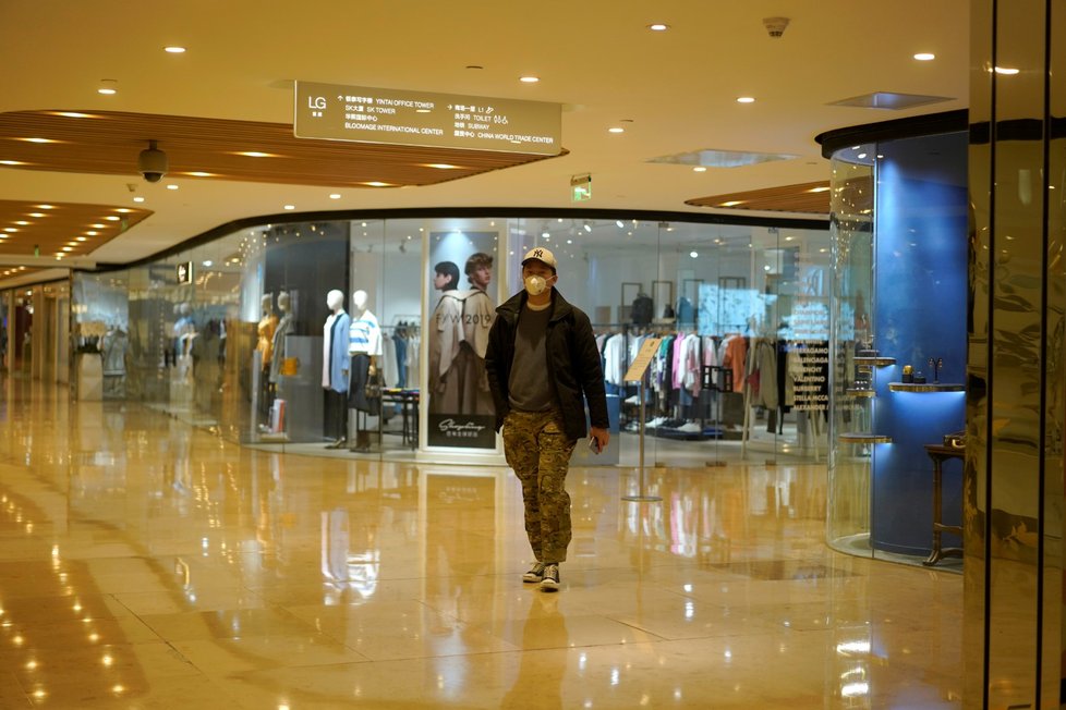 Muž v roušce v obchodním centru v Pekingu (29.2.2020)