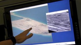 Člen posádky amerického námořnictva ukazuje na obrazovce počítaře čínskou stavbu na půdě ostrovů Spratly.