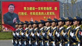 Příslušnice čínské armády pochodují, v pozadí billboard s prezidentem.