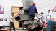 Čínští dělníci nakládají hliníkové ventilační skříně.