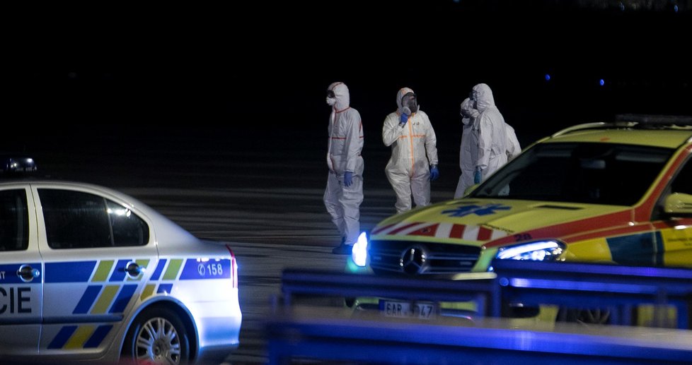 Češi a Slováci z Wu-chanu přistáli v Praze. Personál ve skafandrech je přesouvá do sanitek, s opatrností se zachází i s jejich zavazadly (3. 2. 2020).