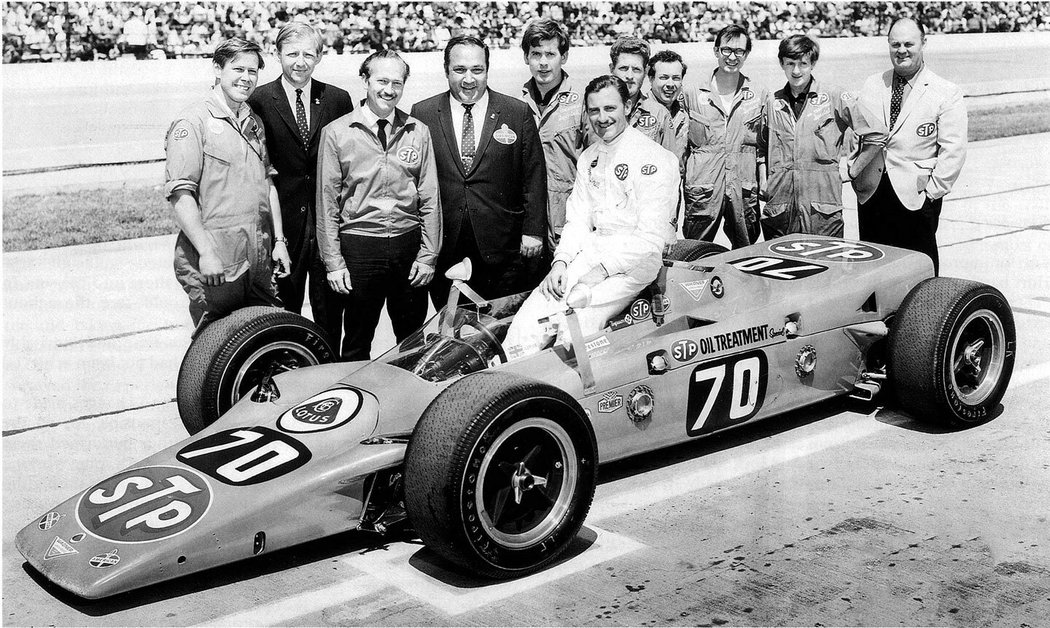 Graham Hill (v kokpitu) po výhře v 500 milích Indianapolis. Chapman stojí třetí zleva.