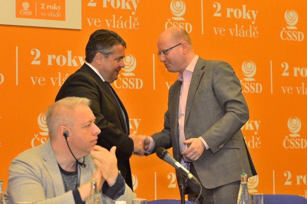 Premiér Bohuslav Sobotka (ČSSD, vpravo) vítá německého vicekancléře Sigmara Gabriela, ministr vnitra Milan Chovanec (ČSSD) tleská.
