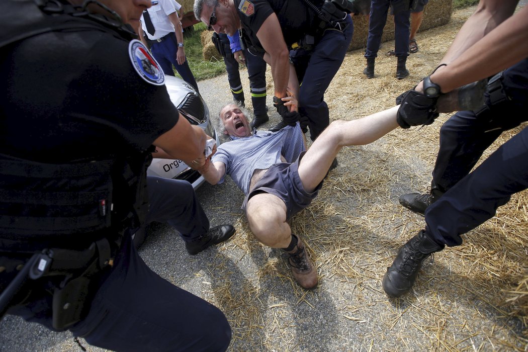 Policisté odnášejí protestující z trati Tour de France