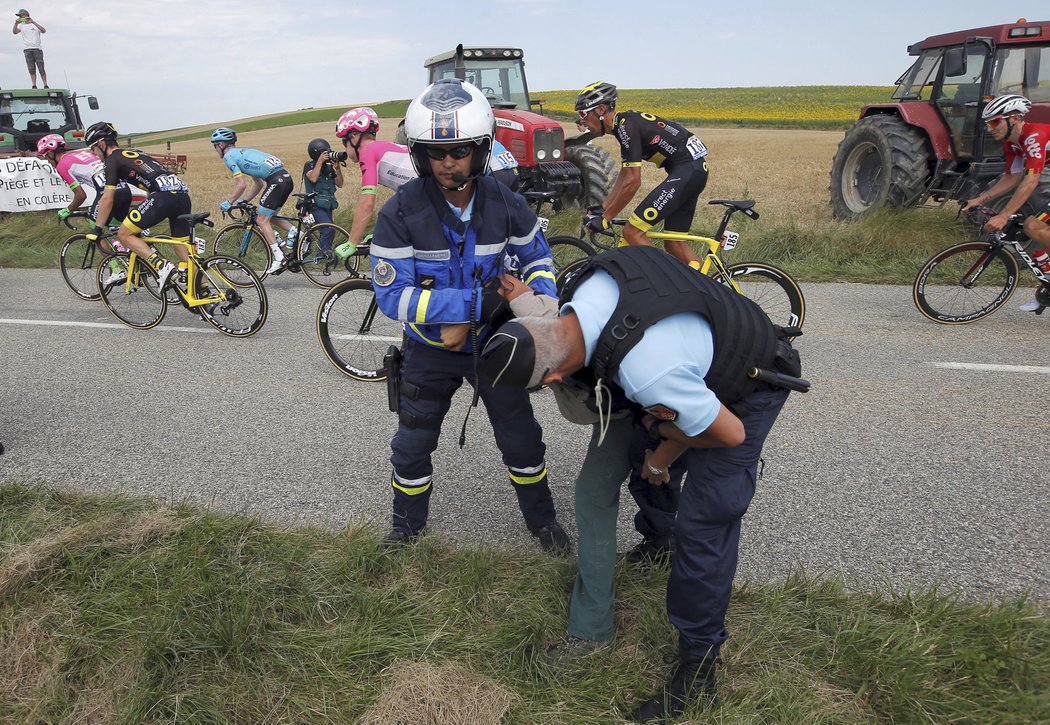 Policisté odvádějí od silnice protestující farmáře