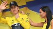 Geraint Thomas si obléká žlutý dres, pomáhá mu hosteska