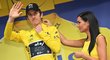 Geraint Thomas si obléká žlutý dres, pomáhá mu hosteska