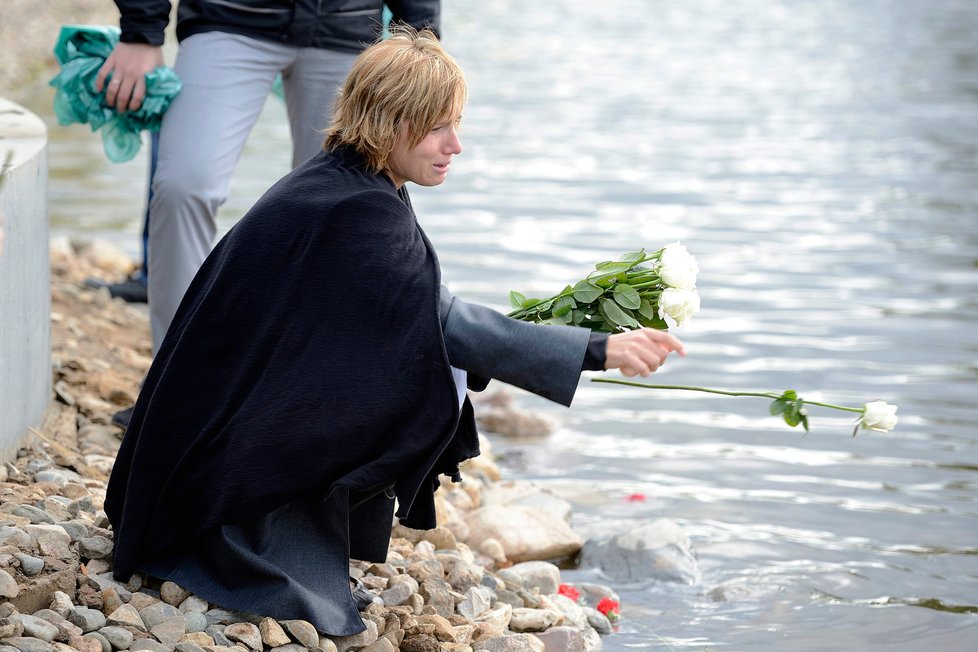 Kateřina Rachůnková, manželka českého hokejisty Karla Rachůnka háže bílou růži do řeky v místě, kde její láska zemřela.