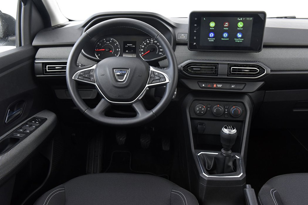 V kabině udělala Dacia asi největší pokrok. Palubní deska působí moderně i díky vystouplému 8“ displeji multimediálního systému. Ten je součástí výbavy Comfort, stejně jako látkou čalouněný okrasný pás nebo kožený multifunkční volant. Útulnější prostředí zatím Dacia nevytvořila a řidič může spoléhat na dobře čitelné přístroje.