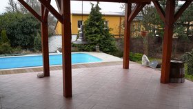 U domu je rozlehlá terasa s vířivkou a bazénem na zahradě.