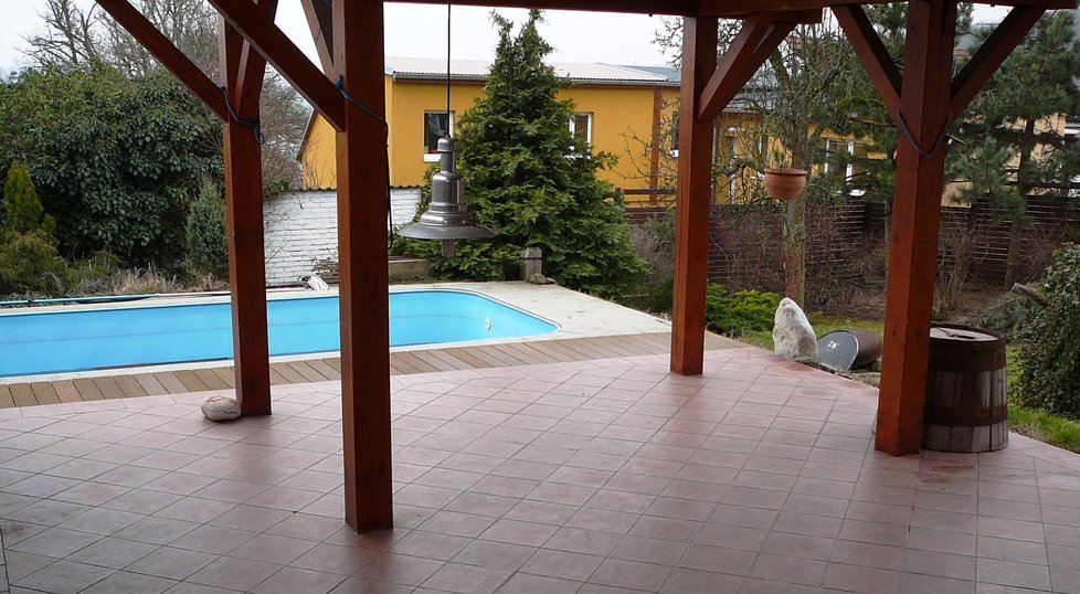 U domu je rozlehlá terasa s vířivkou a bazénem na zahradě.