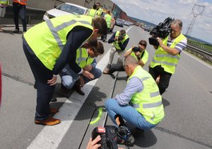 Ministr dopravy Martin Kupka (47, ODS, v podřepu s nohou na bílé čáře) kontroluje kvalitu práce na D1.