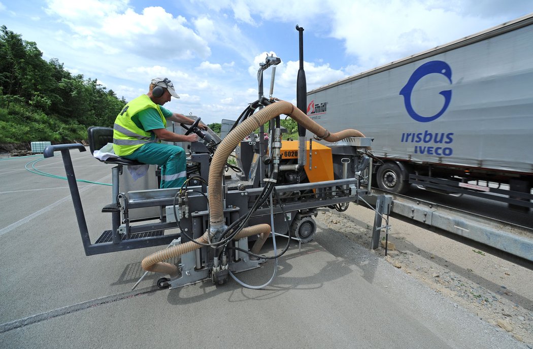 Hned vzápětí jede druhý fi nišer, který položí 5 cm vysokou fi nální betonovou vrstvu s jemnějším kamenivem s protismykovými vlastnostmi a vyšším množstvím cementu.