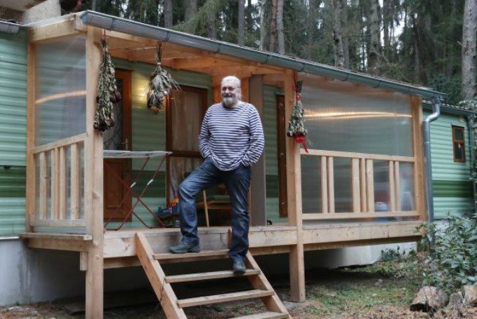 Dvoumetrový Hůlka musí stát na předposledním schůdku, aby mu byla vidět hlava. Mobilheim zdobí suché růže, které zpěvák dostal.