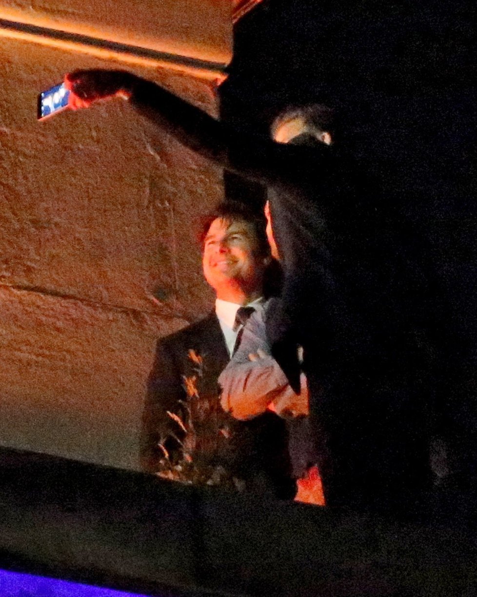 Tom Cruise se kření do foťáku, který v ruce držel David Beckham. Uprostřed stál Guy Ritchie