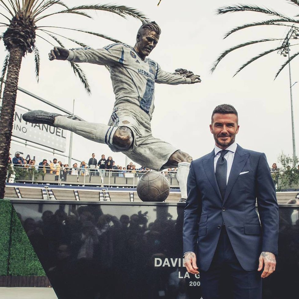 David Beckham hrdě pózuje se svou sochou.