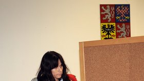 Eva Rathová vychází zpoza opony ve volební místnosti v "Rathově" Hostivici