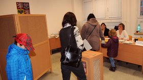 Eva Rathová vhazuje svůj hlas do urny v Hostivici, kde sama kandiduje. Vlevo její syn