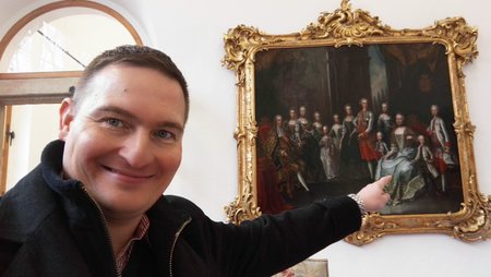 Bývalý mluvčí Správy pražského hradu David Šebek pózuje před obrazem Marie Terezie s rodinou