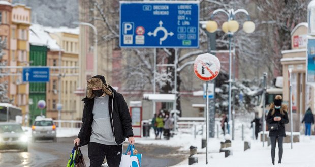 Muž prochází po zasněženém Masarykově náměstí v centru Děčína (14. 1. 2021)