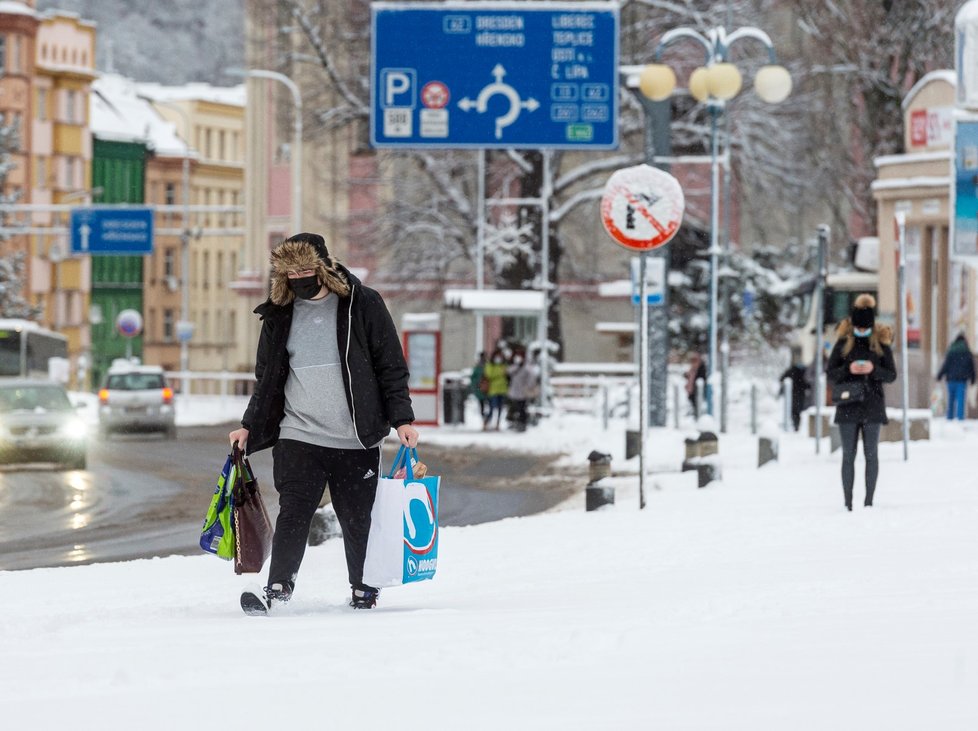 Muž prochází po zasněženém Masarykově náměstí v centru Děčína (14. 1. 2021)