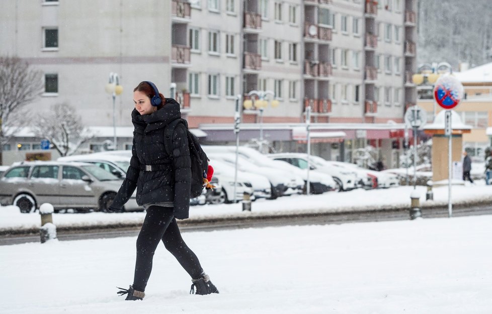 Žena prochází po zasněženém Masarykově náměstí v centru Děčína (14. 1. 2021).