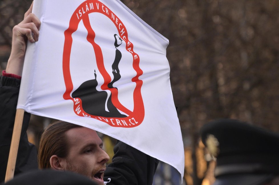 Účastník sobotní demonstrace s vlajkou hnutí Blok proti islámu a Islám v ČR nechceme