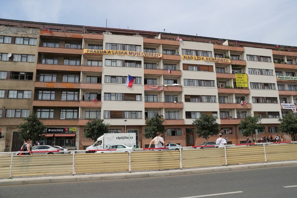 Transparenty vyjadřující podporu demonstrantům na nájemním domě Molochov naproti Letenské pláni (23. 6. 2019)