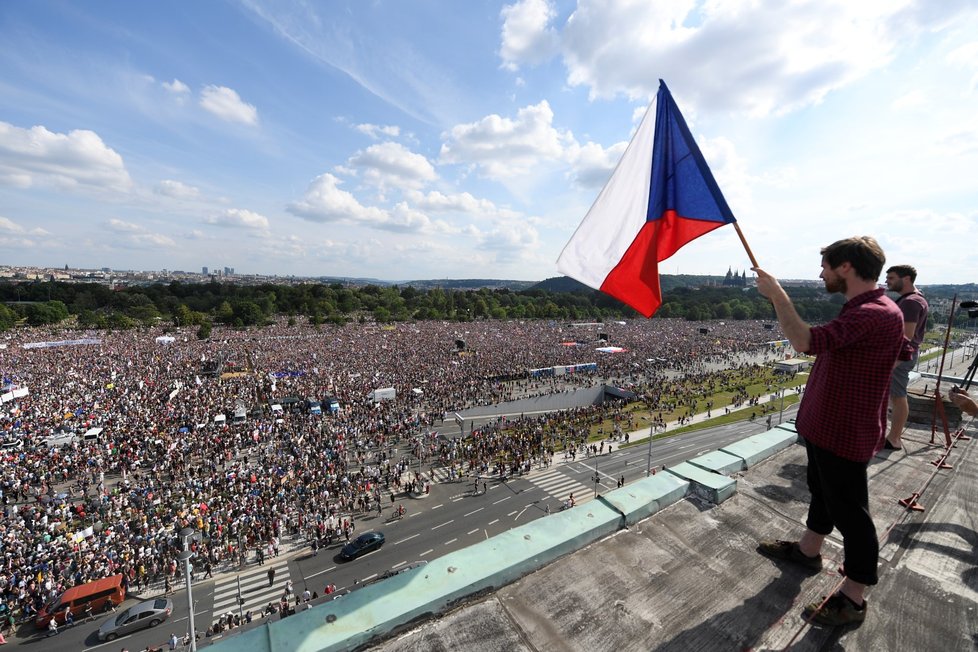 Někteří lidé sledují demonstraci ze střechy nájemního domu Molochov, který leží naproti Letenské pláni (23. 6. 2019)