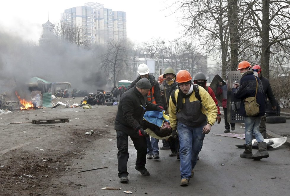 Ukrajinští demonstranti odnáší zraněného druha