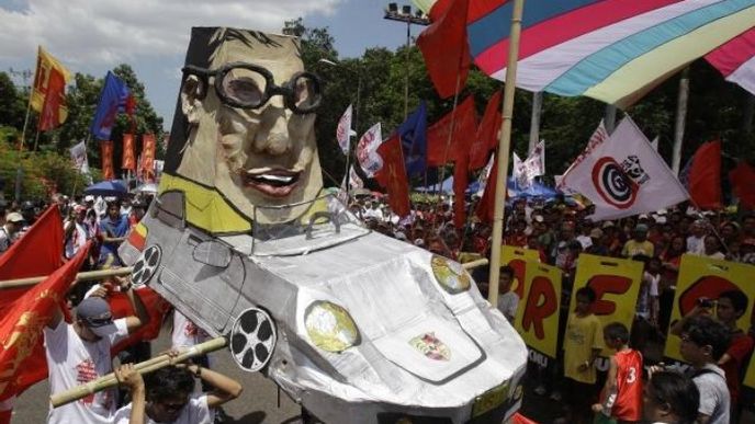demonstranti na Filipínách s karikaturou prezidenta v jeho luxusním voze