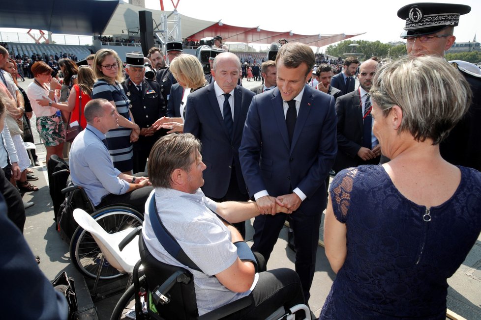 Prezident Francie Emmanuel Macron si podal ruku se zraněným policistou na Dni Bastily v Paříži.