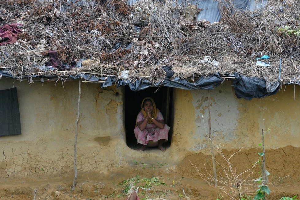 Uprchlice sedí v okně svého domu v Teklafu v Bangladéši.