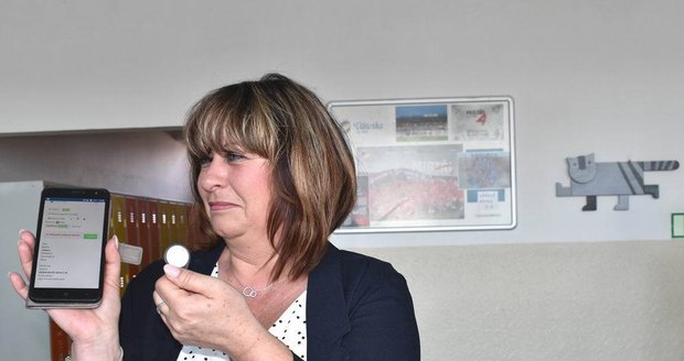 Nový systém vyzvedávání dětí ze školní družiny v Plzni. Vedoucí vychovatelka školy Dana Herličková představuje čipovou kartu a mobilní aplikaci.