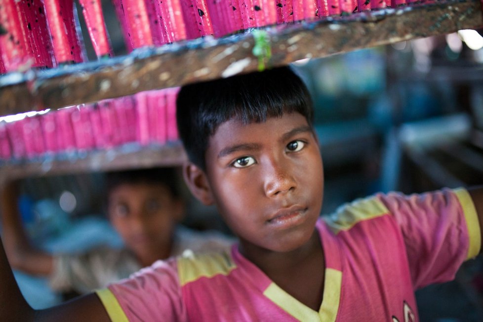 Chlapec v v továrně na balónky v bangladéšské Dháce. Dělníci tu pracují každý den od 6 do 17 hodin. Měsíčně si vydělají v rozmezí od 10 do 25 USD.