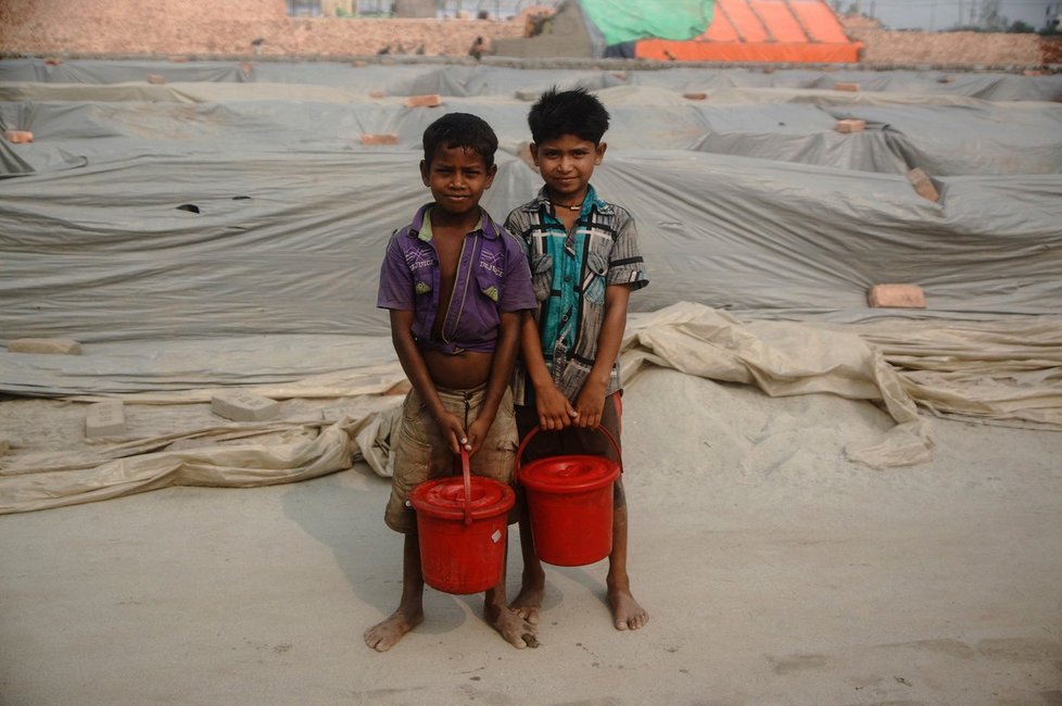 Malí nosiči vody na cihelném poli v bangladéšském městě Rajendrapur.