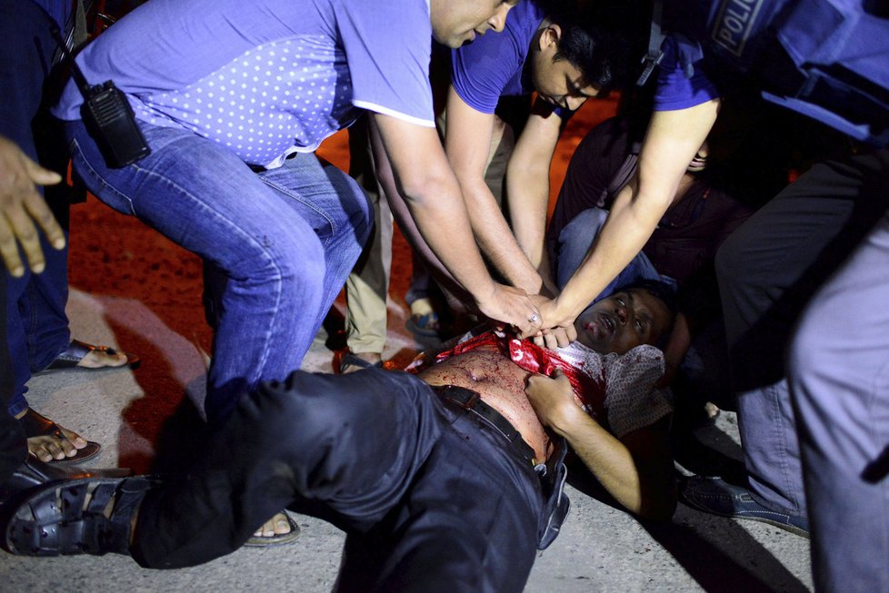 Lidé se snaží pomoci jednomu ze zraněných během teroristického útoku v Dháce, hlavním městě Bangladéše.