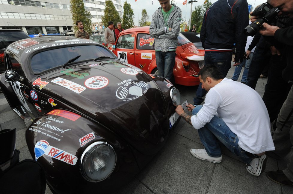 DJ Uwa izolepou připevňuje novou plechovou espézetku na své auto.