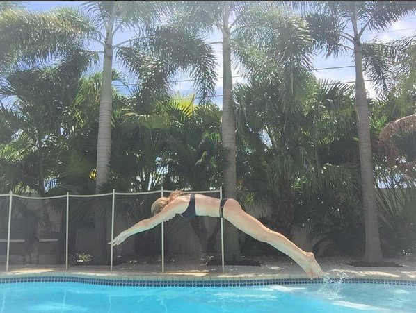 Diana Kobzanová skáče u bazénu šipky.