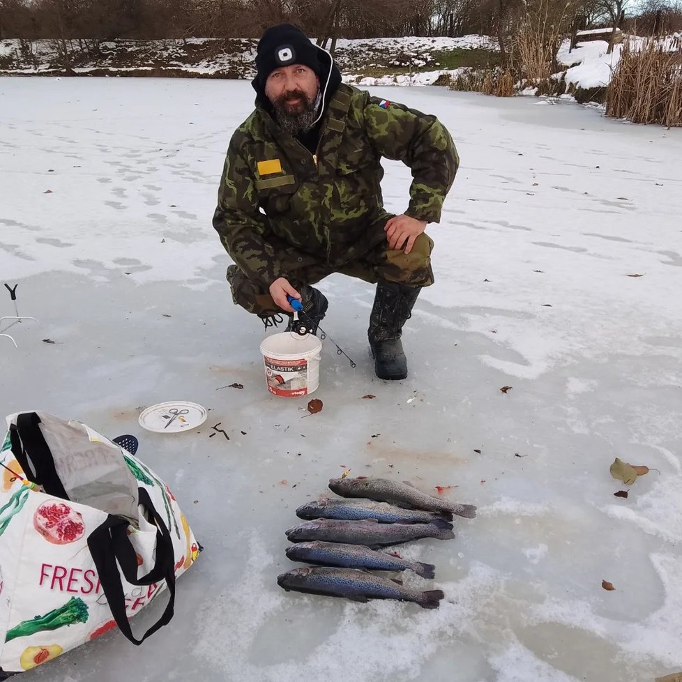 Rybář Petr Weissmann se chlubí tím, co vytáhl zpod ledu.