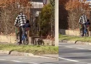 Muž vezl malé dítě na kole. Sedělo v košíku na nákup.