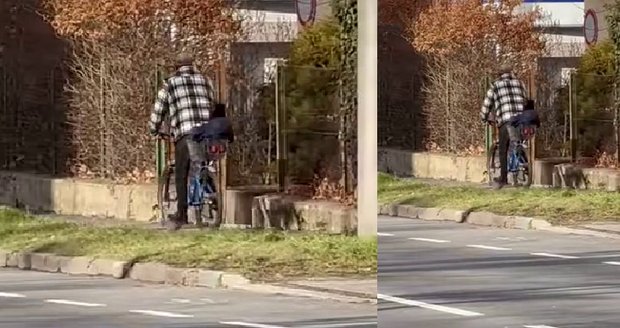 Muž vezl malé dítě na kole. Sedělo v košíku na nákup.