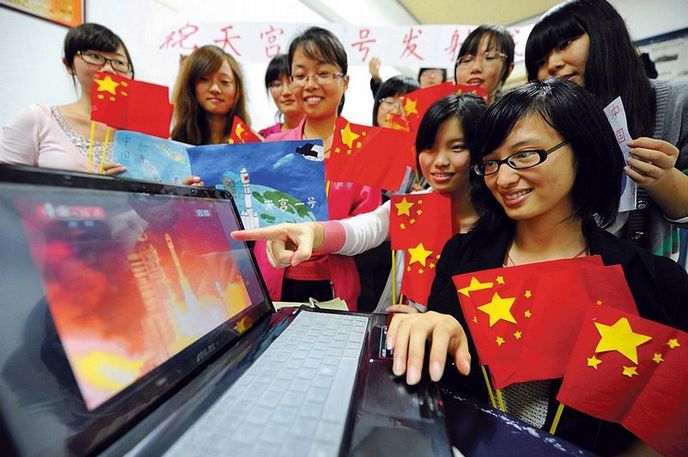 Dobýváme nebesa. Čínští studenti vybavení vlaječkami sledují start rakety s modulem kosmické stanice Tchien-Kung 1. Čína tak loni na podzim
vykročila na cestu ke stálé vesmírné stanici, kterou by chtěla jako třetí země na světě provozovat kolem roku 2020