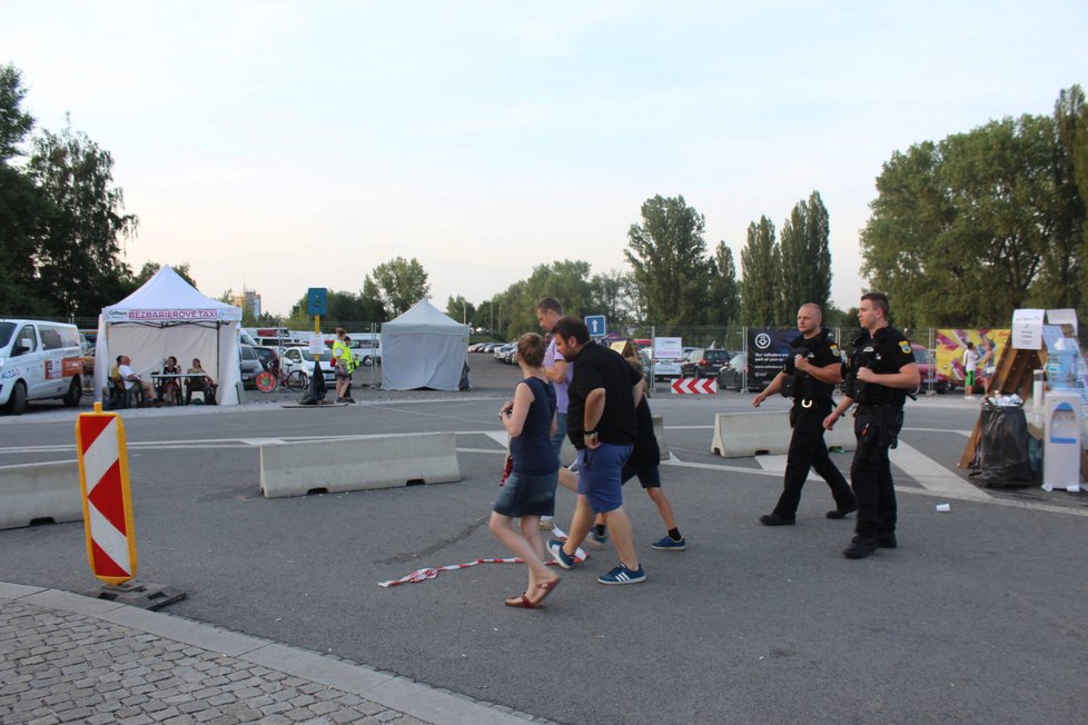 Kolem vchodu se pohybují neustále policisté se samopaly.