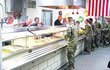 Trump nejdřív osobně vydával vojákům jídlo u bufetového pultu.