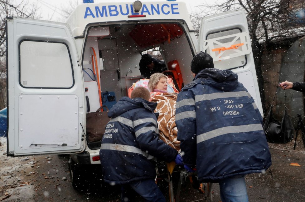 Záchranáři pomáhají ženě v Doněcku.
