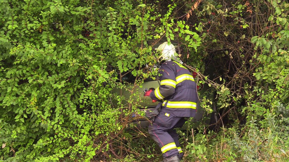 Dopravní nehoda v Broumarské ulici v Praze, po které skončilo auto ve křoví mimo vozovku.