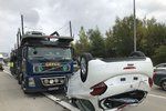 Na Pražském okruhu došlo ke kuriózní nehodě: úplně nové auto spadlo z kamionu, skončilo na střeše.