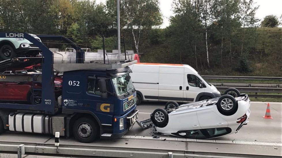 Na Pražském okruhu došlo ke kuriózní nehodě: úplně nové auto spadlo z kamionu, skončilo na střeše.