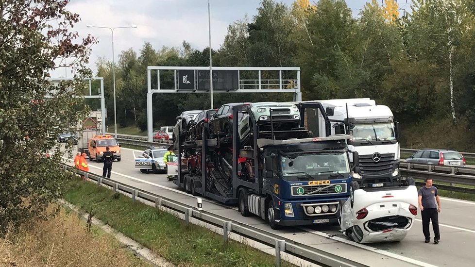 Na Pražském okruhu došlo ke kuriózní nehodě: úplně nové auto spadlo z kamionu, skončilo na střeše.